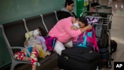Para penumpang beristirahat di Bandara Barcelona, Spanyol, Kamis, 12 Maret 2020.