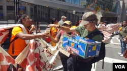 Volunteers hand out free water to protesters at an anti-Trump rally outside the Republican National Convention in Cleveland, Ohio, July 20, 2016. (W. Gallo/VOA)