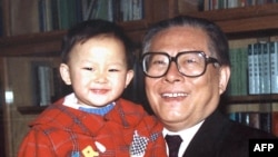1990年代的照片上，中国国家主席江泽民在北京中南海的办公室抱着孙子。