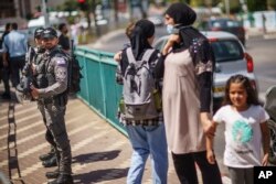 Police stand by during a demonstration calling for justice in the killing of Musa Hassuna in the mixed Arab-Jewish town of Lod, central Israel, Friday, May 28, 2021. (AP Photo/David Goldman)