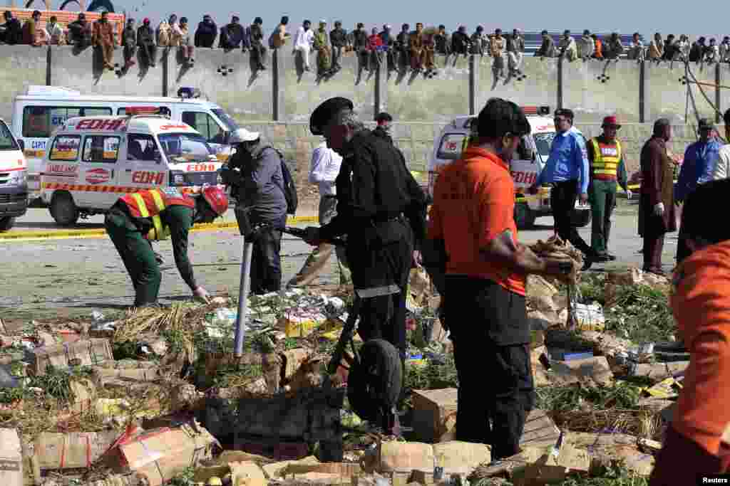Security officials and rescue workers survey the site of a bomb blast at a vegetable and fruit market in the outskirts of Islamabad, April 9, 2014. 