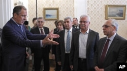 Russian Foreign Minister Sergey Lavrov, left, welcomes a delegation headed by a leader of the Syrian National Council, Abdulbaset Sieda, right, in Moscow, Russia, July 11, 2012.