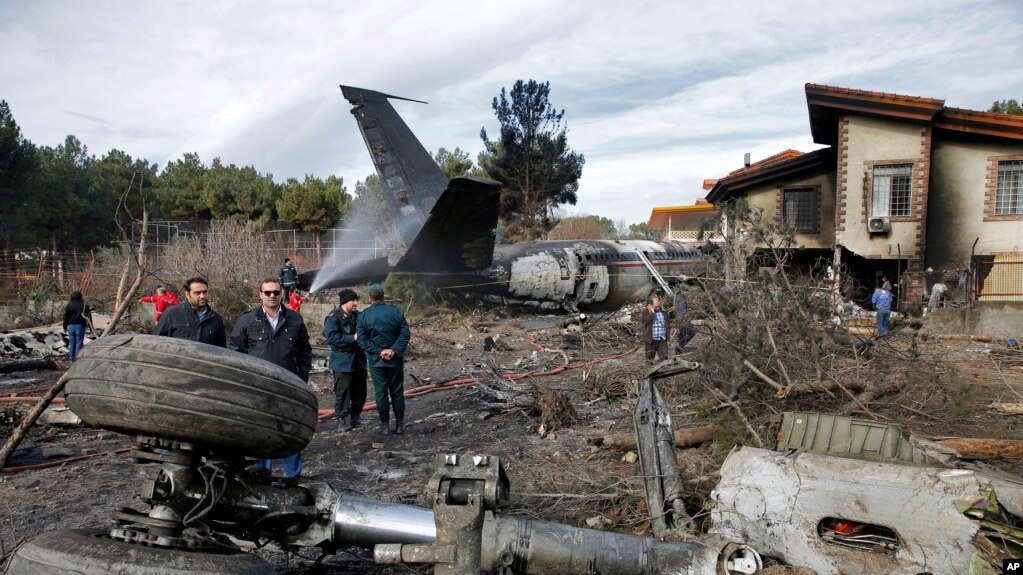 Waokoaji wakiwa katika eneo la ajali na vyombo vya usalama vikifanya kazi pamoja baada ya ndege hiyo ya mizigo aina ya Boeing 707 kuanguka uwanja wa ndege wa Fath magharibi mwa Tehran, Iran, Jumatatu, Jan. 14, 2019.