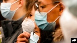 Students wear masks to protect against the coronavirus and COVID-19 during a ceremony to mark the 32th anniversary of the fall of the Berlin Wall in Berlin, Germany, Nov. 9, 2021. Germany's rate of infections has been climbing steadily in recent weeks.