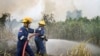 Fire fighters spray water to extinguish wildfires in Pekanbaru, Riau province, Indonesia, Feb. 27, 2014.