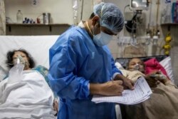 Rohan Aggarwal, 26, seorang dokter residen yang merawat pasien yang menderita COVID-19, menulis catatan selama shift 27 jamnya di Rumah Sakit Keluarga Suci di New Delhi, India, 1 Mei 2021. (Foto: Reuters)