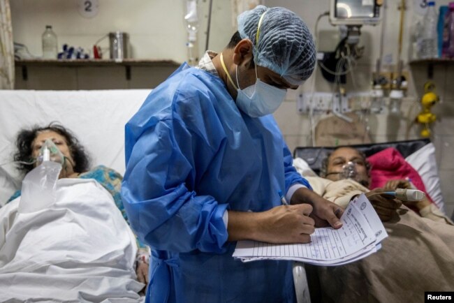 Rohan Aggarwal, 26, seorang dokter residen yang merawat pasien yang menderita COVID-19, menulis catatan selama shift 27 jamnya di Rumah Sakit Keluarga Suci di New Delhi, India, 1 Mei 2021. (Foto: Reuters)