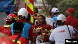 Un bombero es evacuado durante el incendio en el centro comercial Larcomar de Lima, Perú. 