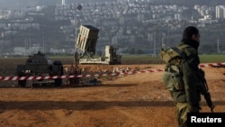An Israeli soldier stands guard next to an Iron Dome rocket interceptor battery deployed near the northern Israeli city of Haifa, January 28, 2013.