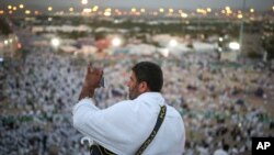 A Muslim pilgrim takes a photo with his mobile phone from atop a rocky hill called the Mountain of Mercy, on the Plain of Arafat, near the holy city of Mecca, Saudi Arabia, Wednesday, Sept. 23, 2015.