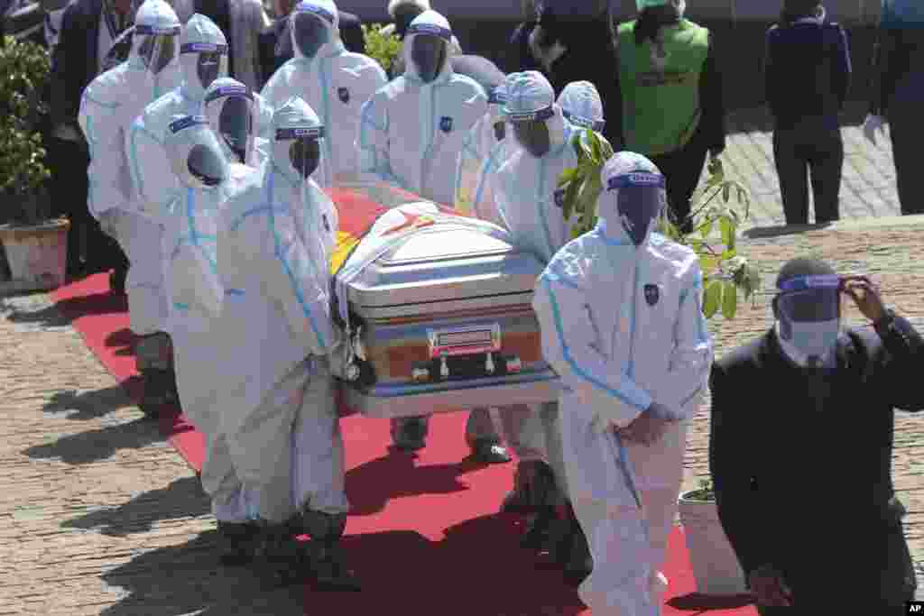 Health officials carry the coffin of Zimbabwean minister Perence Shiri, who died of COVID-19, during his burial in Harare.