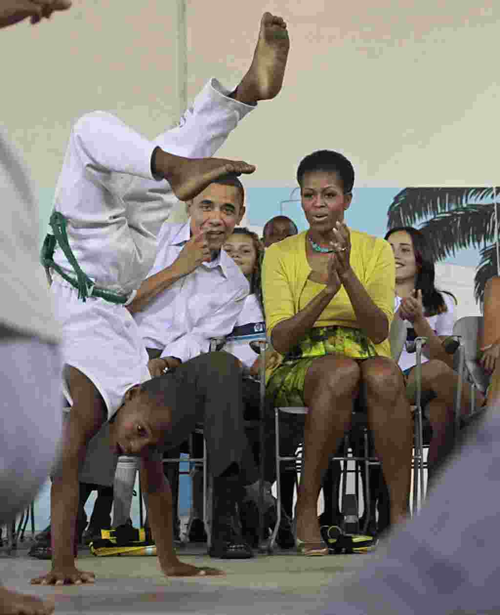 La primera dama estadounidense Michelle Obama observa una presentación de capoeira, en la favela Ciudad de Dios, en Río de Janeiro.
