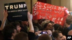 Police attempt to remove protesters as Republican presidential candidate Donald Trump speaks during a campaign rally Friday, March 11, 2016, in St. Louis