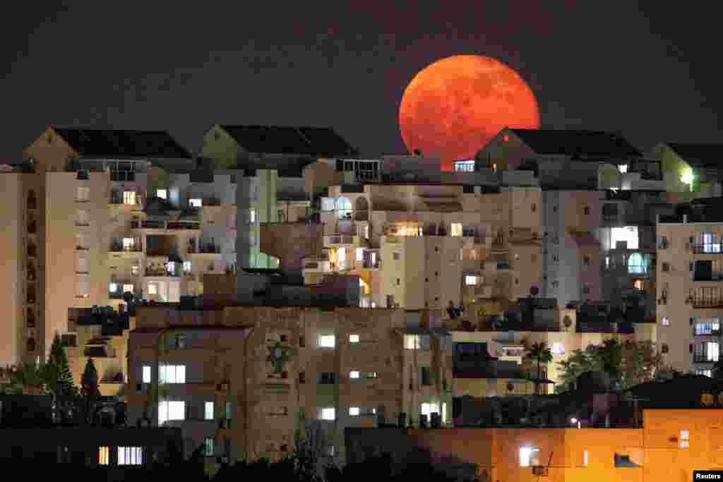 A full moon is seen behind buildings at night in Ashkelon, southern Israel, Dec. 1, 2020.
