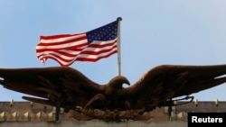 A United States flag is seen flying above an eagle atop a U.S. embassy building (file photo).