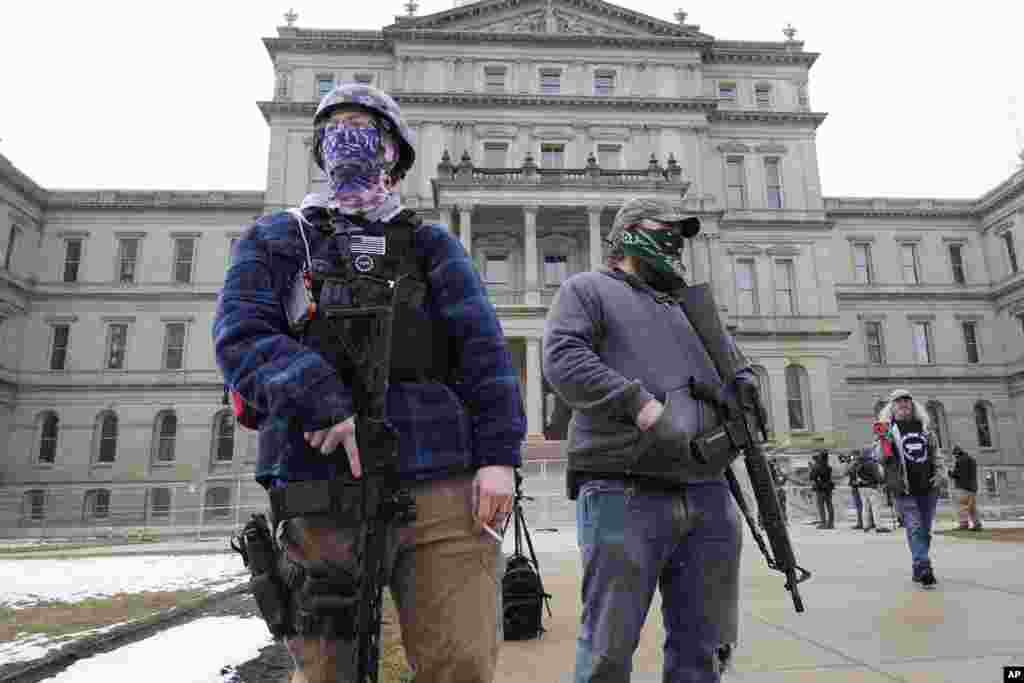 Two men with rifles stand outside the state Capitol in Lansing, Michigan.
