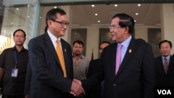 Cambodia's Prime Minister Hun Sen (R) shakes hand with Sam Rainsy (L) president of the Cambodia National Rescue Party (CNRP), after the National Assembly's vote to select the members of National Election Committee in Phnom Penh, Cambodia on April 9th, 201