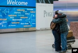 Abdullah Alghazali, right, hugs his 13-year-old son Ali Abdullah Alghazali after the Yemeni boy stepped out of an arrival entrance at John F. Kennedy International Airport in New York, Feb. 5, 2017.