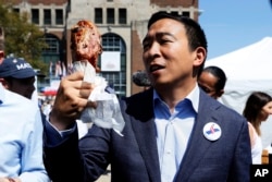 Democratic presidential candidate Andrew Yang holds a turkey leg during a visit to the Iowa State Fair, Friday, Aug. 9, 2019, in Des Moines, Iowa. (AP Photo/Charlie Neibergall)