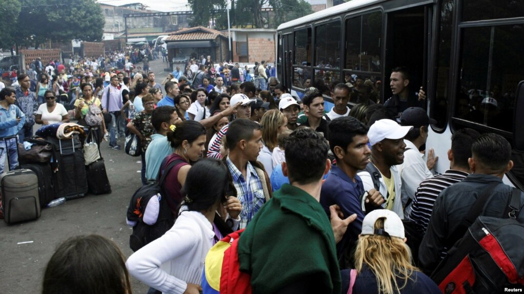 Migrantes venezolanos tratan de abordar un bus que los lleve a la frontera con Colombia desde la frontera San Cristóbal, en Venezuela.