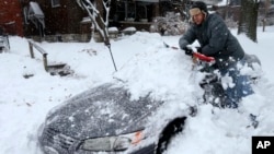 Một cư dân dọn tuyết khỏi xe ô tô ở St. Louis, Missouri, hôm 12/1.