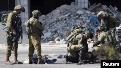 El cuerpo de un palestino que achuchilló a un soldado israelí yace en el suelo luego de ser abatido en Hebrón.