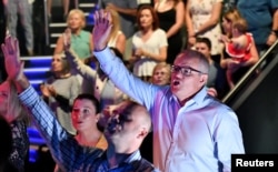 FILE - Prime Minister Scott Morrison and wife Jenny sing during an Easter Sunday service at his Horizon Church at Sutherland in Sydney, April 21, 2019. (AAP Image/Mick Tsikas/via Reuters)