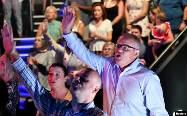 FILE - Prime Minister Scott Morrison and wife Jenny sing during an Easter Sunday service at his Horizon Church at Sutherland in Sydney, April 21, 2019. (AAP Image/Mick Tsikas/via Reuters)