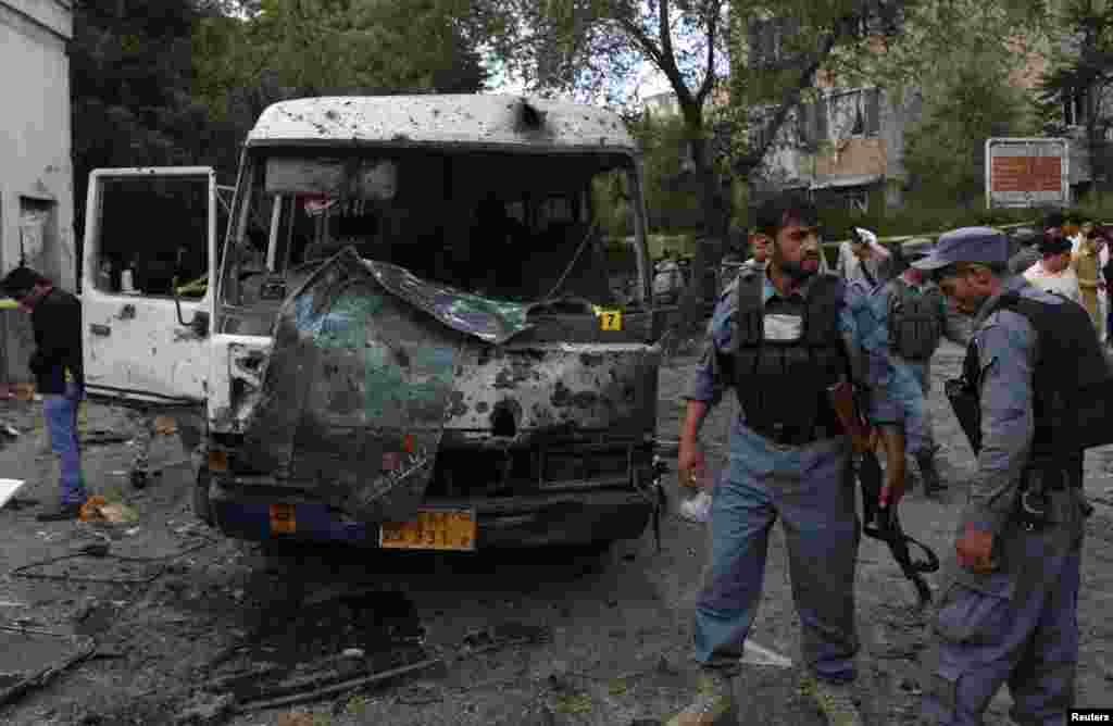 Afghan police stand at the site of a suicide car bomb attack in Kabul, June 11, 2013.
