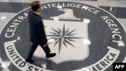 FILE - A man crosses the Central Intelligence Agency (CIA) logo in the lobby of CIA Headquarters in Langley, Virginia.