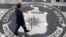 FILE - A man crosses the Central Intelligence Agency logo in the lobby of CIA Headquarters in Langley, Virginia.