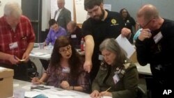 Election officials in Newport News, Va., examine ballots that a computer failed to scan during a recount for a House of Delegates race, Dec. 19, 2017. 
