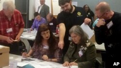 Election officials in Newport News, Va., examine ballots during a recount for a House of Delegates race, Dec. 19, 2017. (AP Photo/Ben Finley)