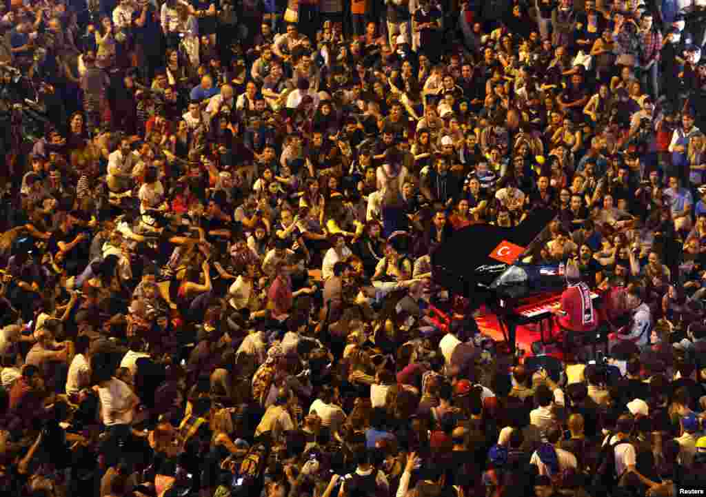German pianist Davide Martello is surrounded by anti-government protesters as he performs in Istanbul's Taksim Square, June 13, 2013. 
