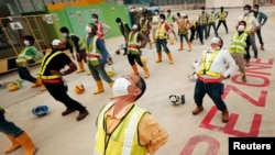 Pekerja konstruksi di Singapura melakukan senam pagi sambil memakai masker karena adanya kabut asap. (Foto: Dok)