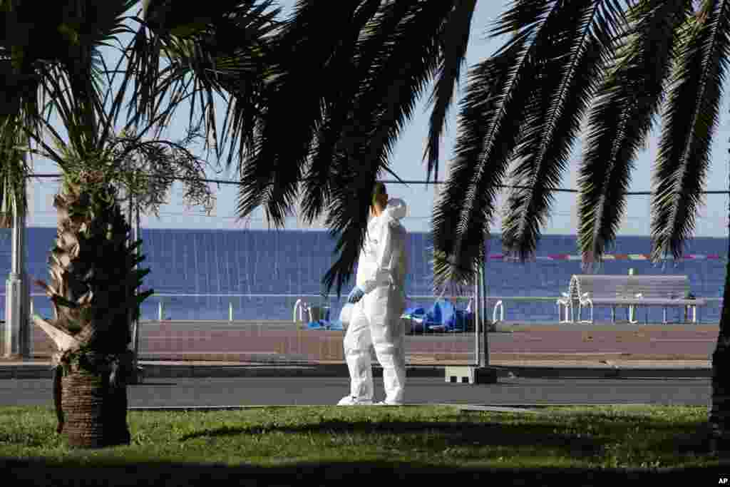 Bodies of victims covered by sheets at the scene of a truck attack in Nice, southern France, Friday, July 15, 2016.