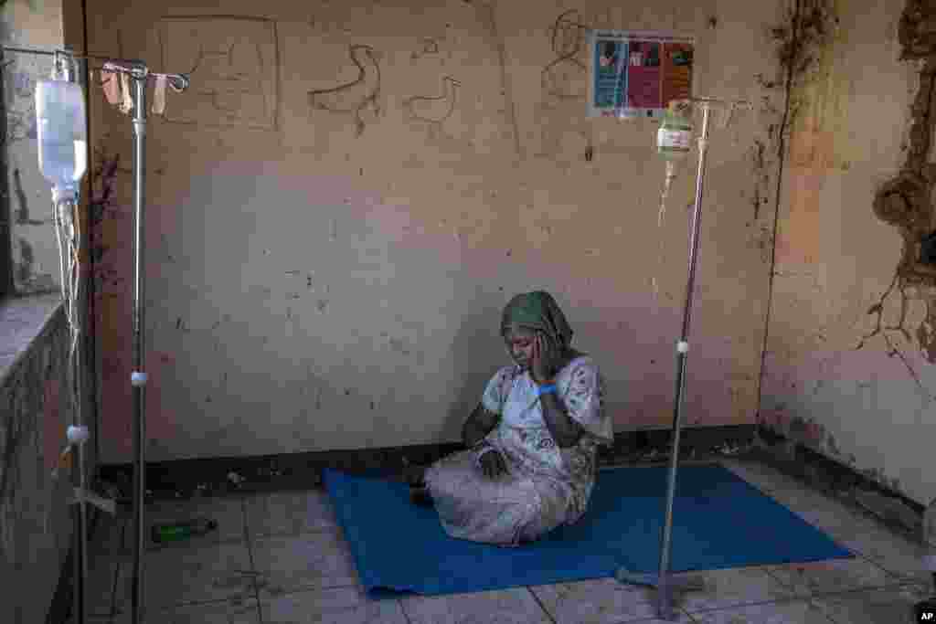 A Tigray woman who fled the conflict in Ethiopia&#39;s Tigray region, waits to get treatment at a clinic in Umm Rakouba refugee camp in Qadarif, eastern Sudan, Nov. 25, 2020.