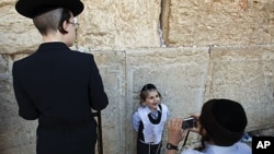 An ultra-Orthodox Jewish boy has his photograph taken at the Western Wall, Judaism's holiest prayer site, in Jerusalem's Old City September 28, 2011.