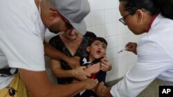 Seorang anak lelaki menangis saat disuntik vaksin anti demam kuning di sebuah puskesmas di Sao Paulo, Brazil, Selasa, 16 Januari 2018 (foto: AP Photo/Andre Penner).
