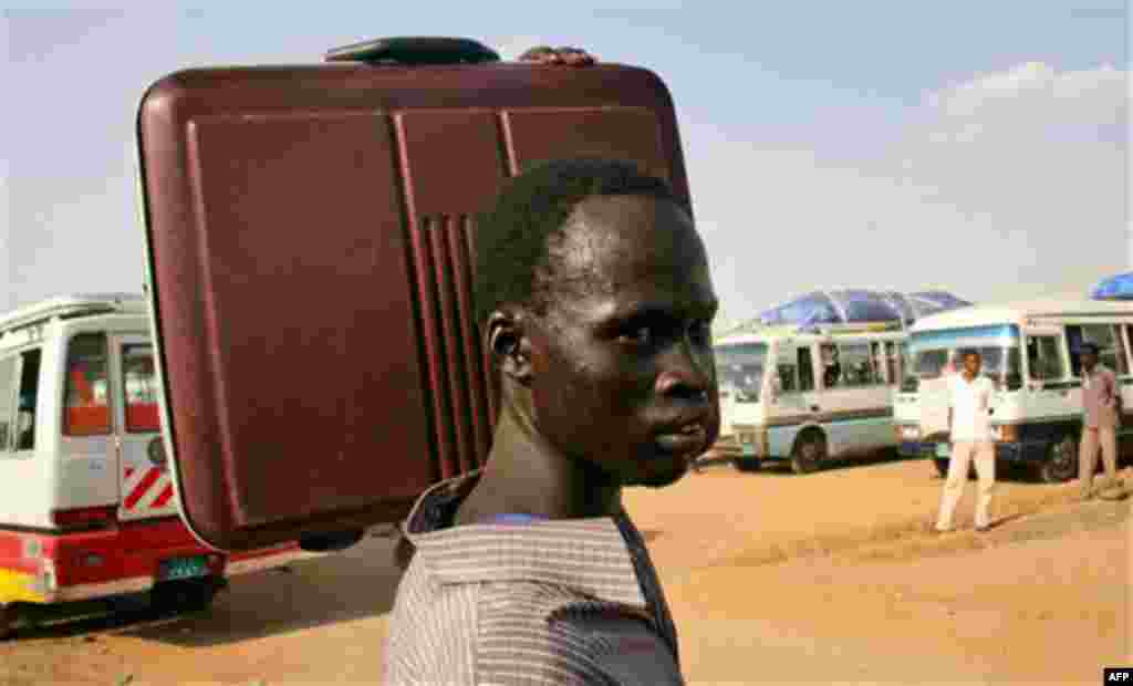 A southern Sudanese man carries his suitcase as he makes his way to a bus headed to southern Sudan, at a staging area 20 miles south of Khartoum, Sudan, Thursday, Oct. 28, 2010. Hundreds of southern Sudanese began heading south from the capital Khartoum T