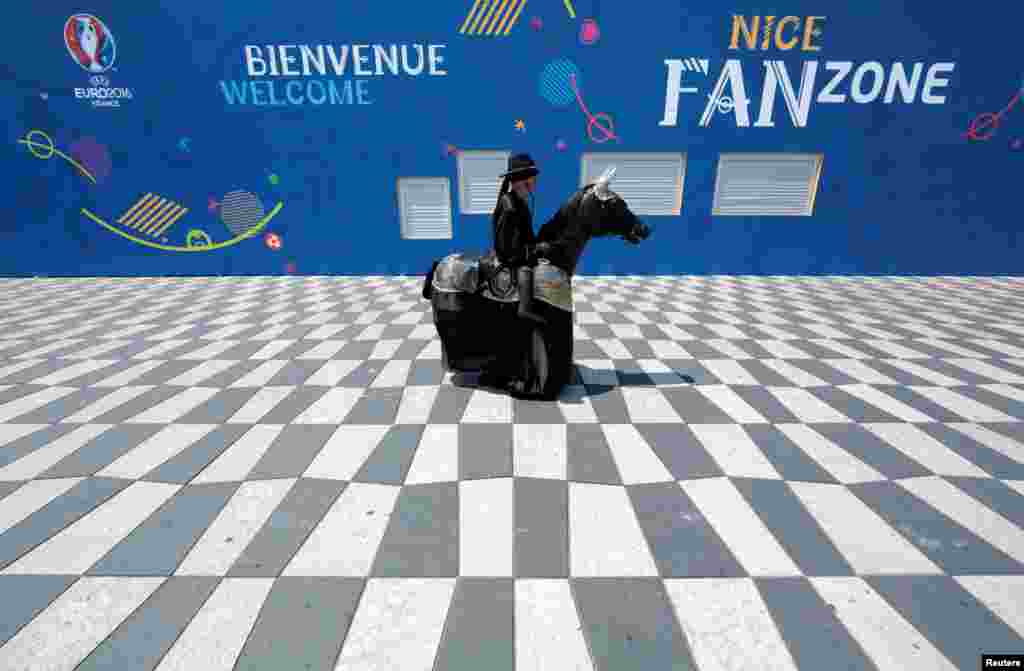 A street artist wearing a 'Zorro' costume walks past a fan zone before the start of the UEFA 2016 European Championship in Nice, France, June 7, 2016..