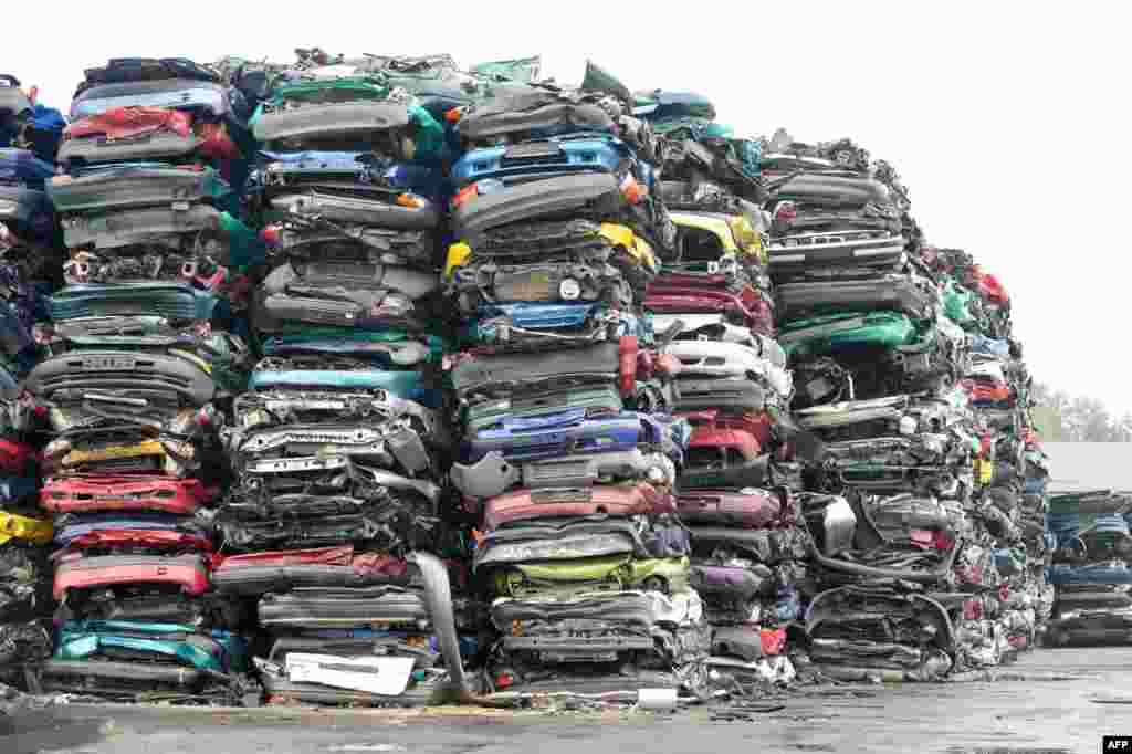 Compressed cars piled up in freight-friendly bales of scrap await their transport on the grounds of a car recycling company in Krostitz, eastern Germany, Oct. 6, 2015.