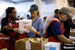 First lady Melania Trump helps a volunteer hand out meals during a visit with flood survivors of Hurricane Harvey at a relief center in Houston, Texas, Sept. 2, 2017.