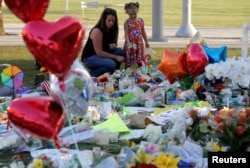 People visit a vigil for the victims of the shooting at the Pulse gay nightclub in Orlando, Florida, U.S. June 14, 2016.