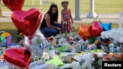 People visit a vigil for the victims of the shooting at the Pulse gay nightclub in Orlando, Florida, U.S. June 14, 2016.