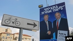 Papan pemilu Partai Likud bergambar Presiden AS Donald Trump (kiri) bersalaman dengan Ketua Likud sekaligus Perdana Menteri Israel Benjamin Netanyahu, di sebuah jalan di Yerusalem, 16 September 2019.