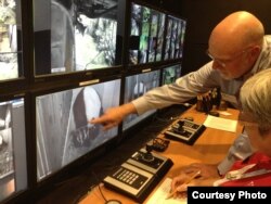 FILE - National Zoo director Dennis Kelly and a webcam volunteer watch Mei Xiang and her new cub, Bao Bao, via the Giant Panda Cam in 2013. (Credit: Smithsonian's National Zoo)