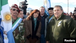 Argentina's President Cristina Fernandez de Kirchner (C) poses with Argentine war veterans during a ceremony to pay homage to the fallen soldiers during the Falklands War in Ushuaia, April 2, 2015.