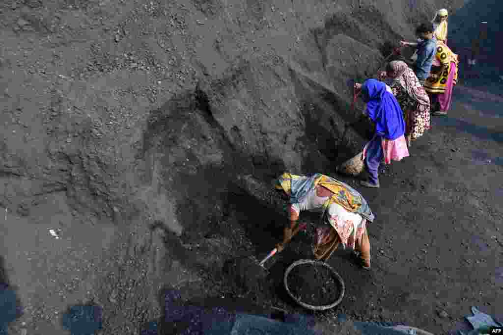 Workers put coal into baskets in Dhaka, Bangladesh.