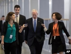 Sen. Ron Johnson, R-Wis., center, who has expressed opposition to his party's health care bill, walks to a policy meeting at the Capitol in Washington, June 27, 2017.